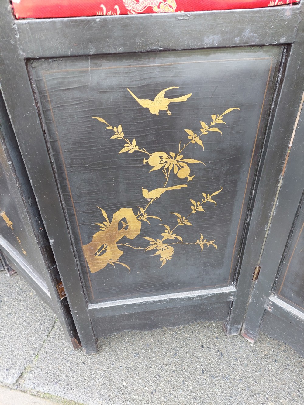 An eight-panel black lacquered folding screen with gold chinoiserie figures and floral patterned panels. View XII