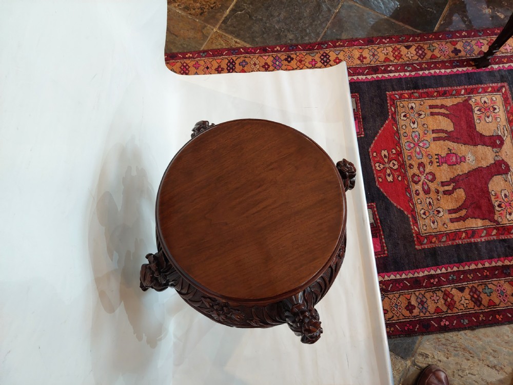 A dark mahogany circular jardiniere stand featuring elaborate floral relief carving around the deep apron and sweeping cabriole legs. View IV