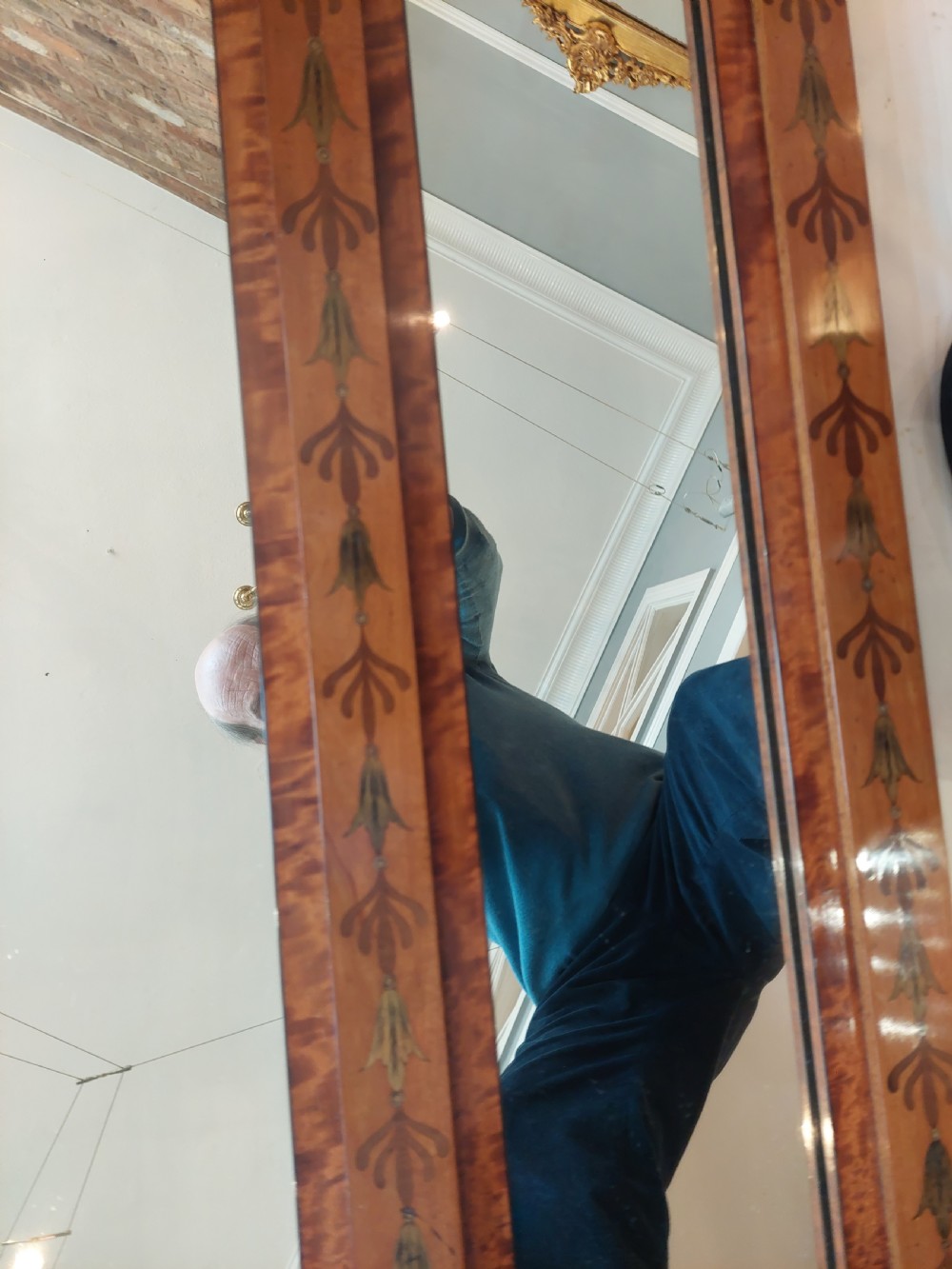 A wide satinwood overmantel mirror featuring three glass panels surrounded by a frame decorated with painted foliage swags and husk garlands. View IV