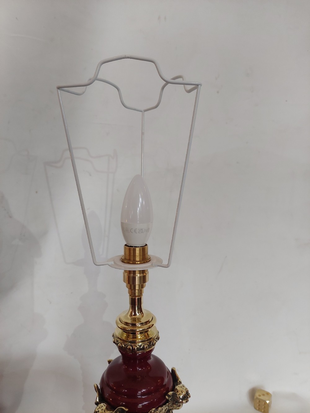 A late nineteenth-century Rococo Revival table lamp featuring a red glazed body with ornate gilt bronze scroll mounts and a red beaded fringe dome shade. View XI
