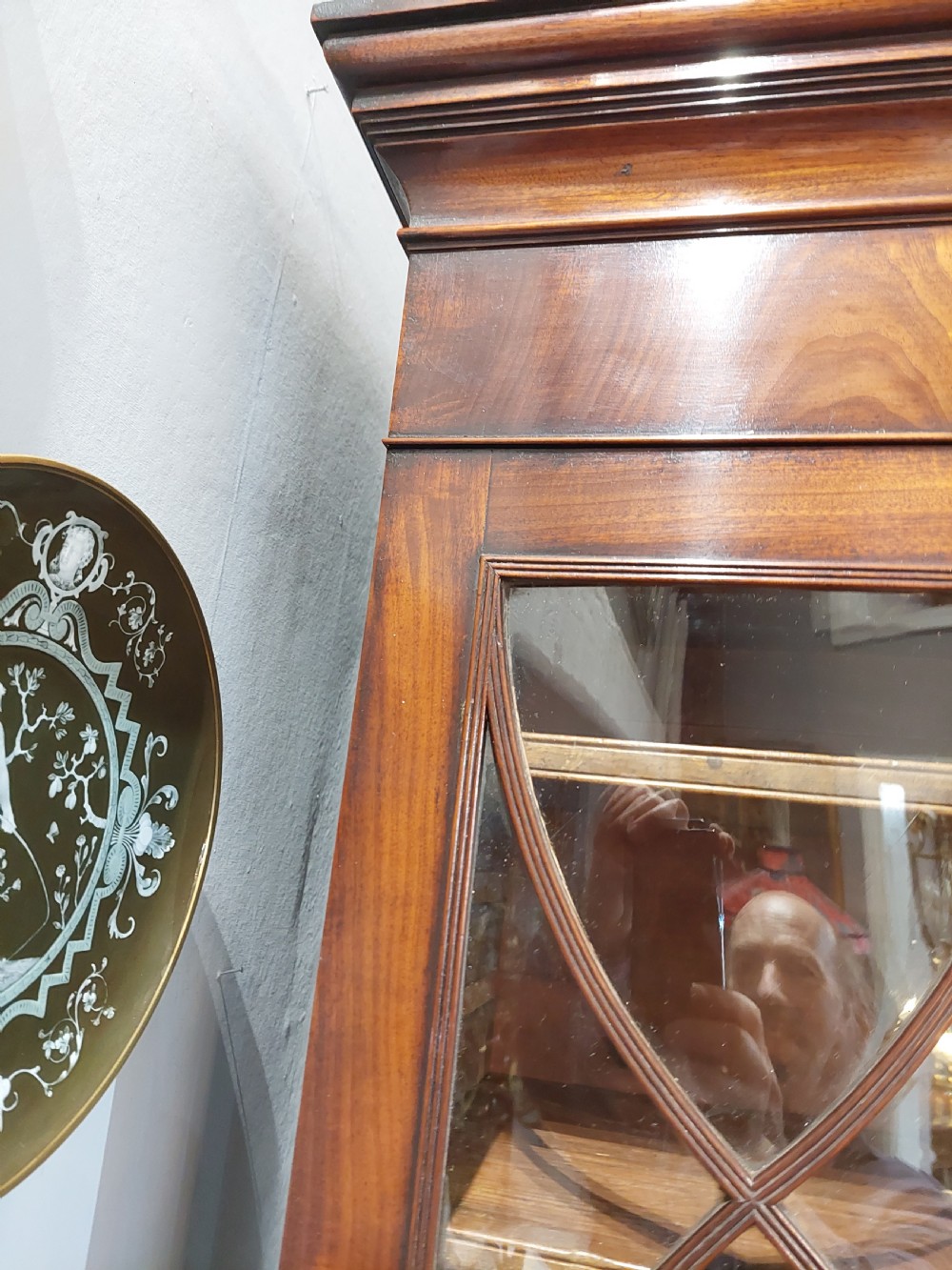 A tall Regency mahogany secretaire bookcase featuring two upper glazed doors with intricate geometric glazing bars above a chest of drawers with oval brass handles. View XIX