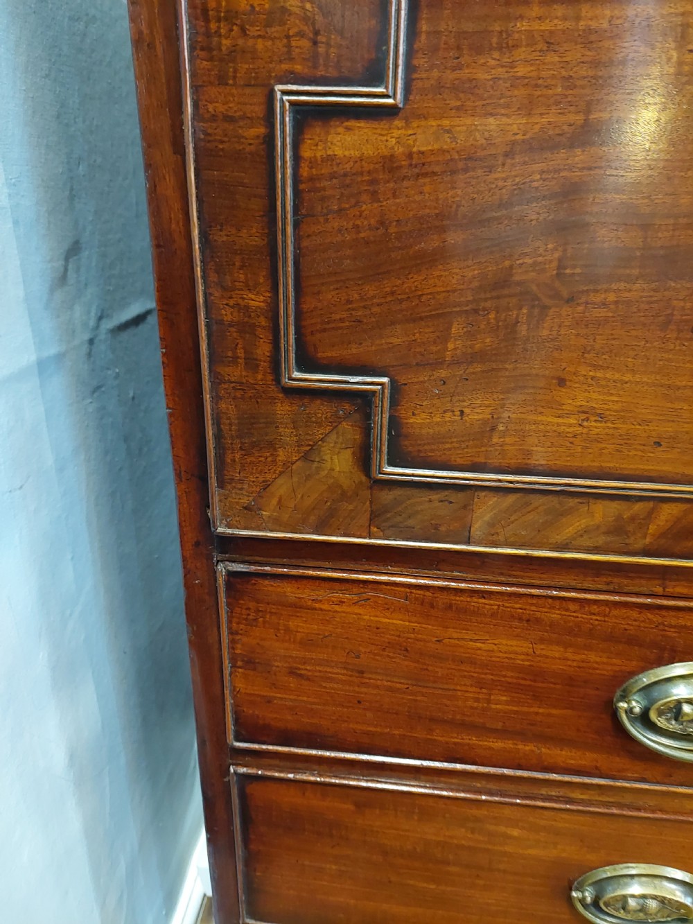 A tall Regency mahogany secretaire bookcase featuring two upper glazed doors with intricate geometric glazing bars above a chest of drawers with oval brass handles. View XXI