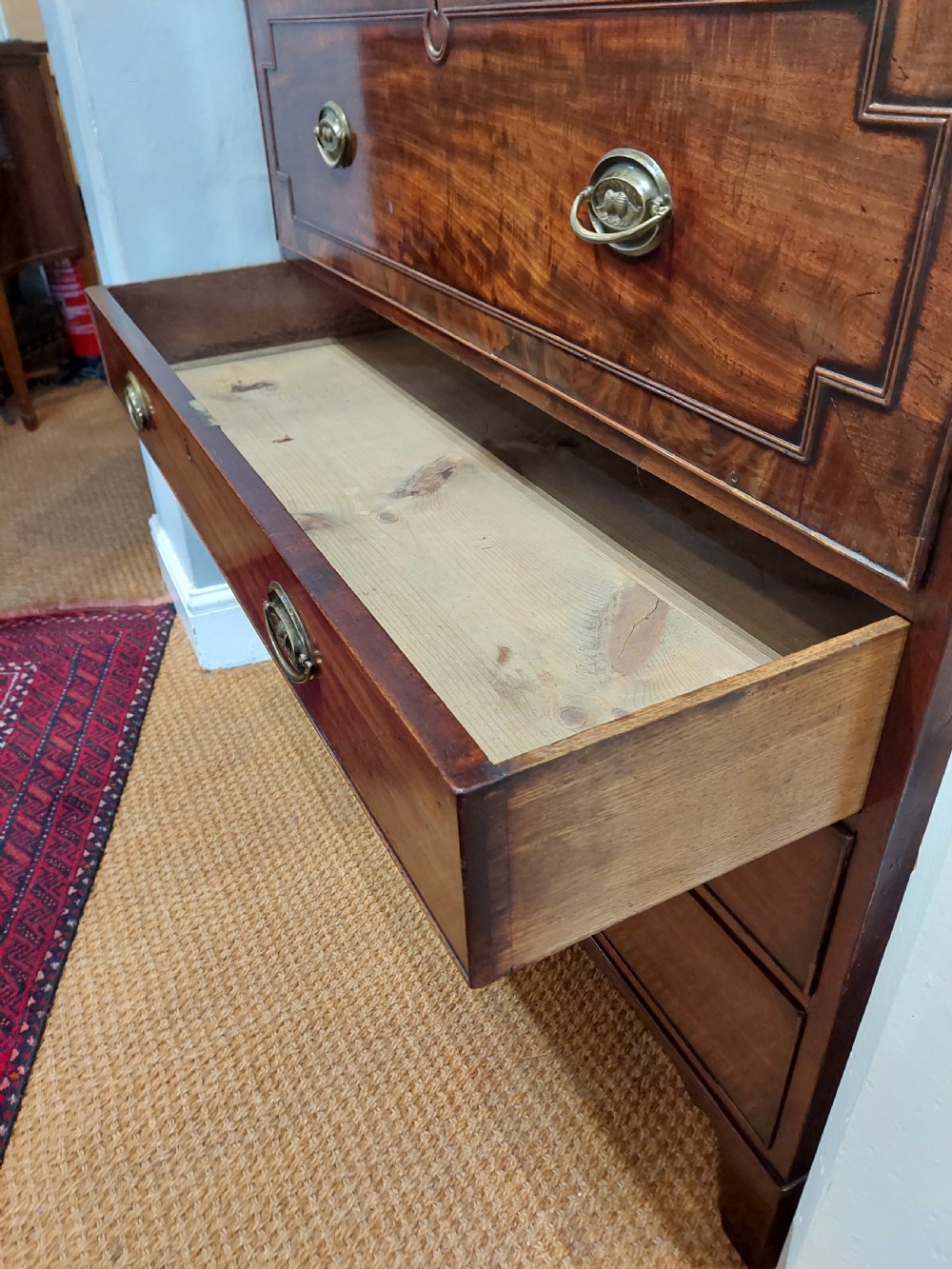 A tall Regency mahogany secretaire bookcase featuring two upper glazed doors with intricate geometric glazing bars above a chest of drawers with oval brass handles. View XXV