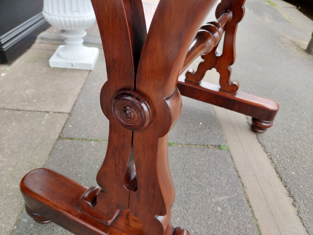 A Regency rosewood sofa table featuring a figured timber top, single frieze drawer with brass knobs, a turned central stretcher, and trestle legs. View V