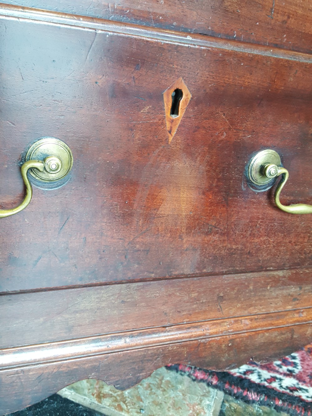 A George III mahogany Lancashire mule chest with brass swan-neck handles, fluted quarter columns, diamond keyhole inlays, and ogee bracket feet. View VI