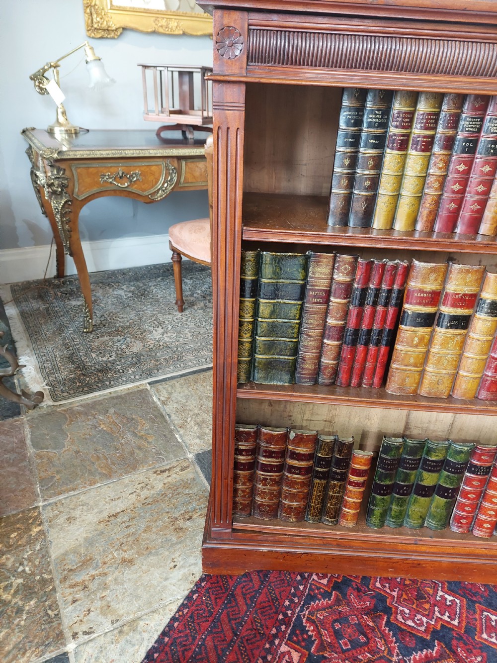 A late 19th-century mahogany dwarf open bookcase with a reeded top frieze, fluted side pilasters, and three fixed shelves. View IV