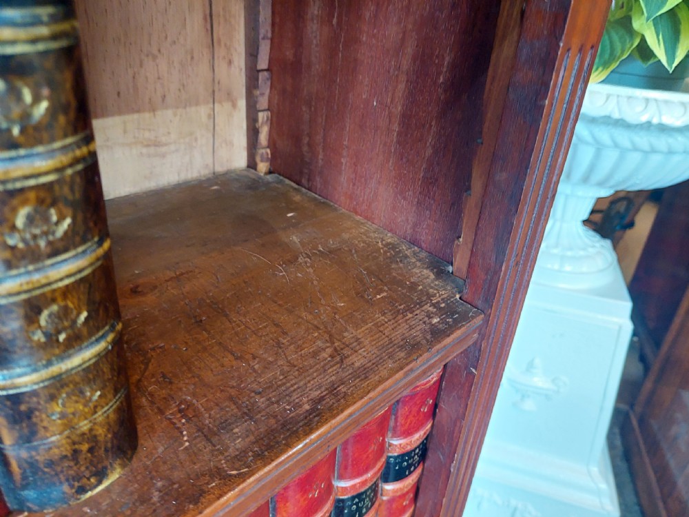 A late 19th-century mahogany dwarf open bookcase with a reeded top frieze, fluted side pilasters, and three fixed shelves. View V