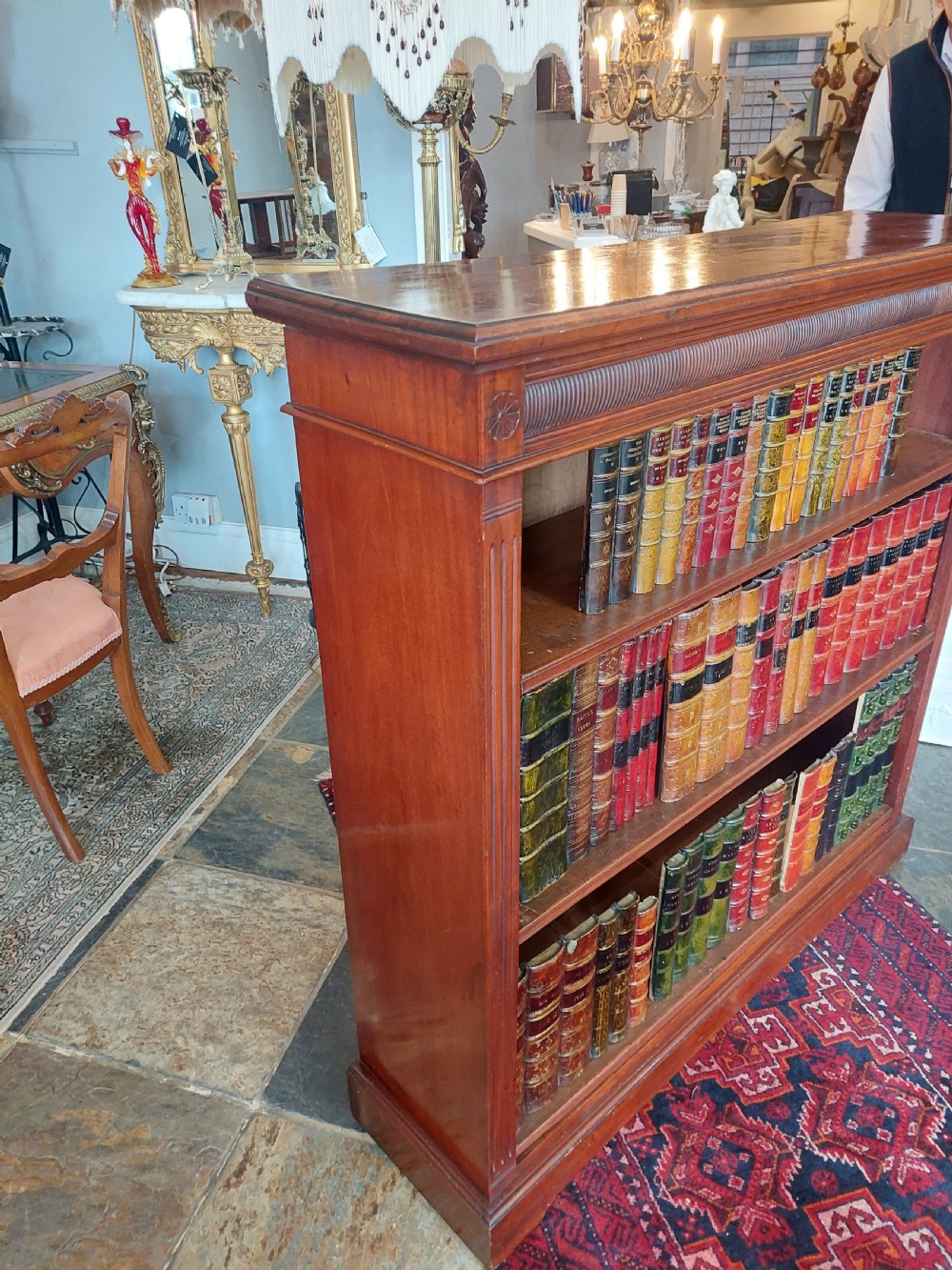 A late 19th-century mahogany dwarf open bookcase with a reeded top frieze, fluted side pilasters, and three fixed shelves. View VII