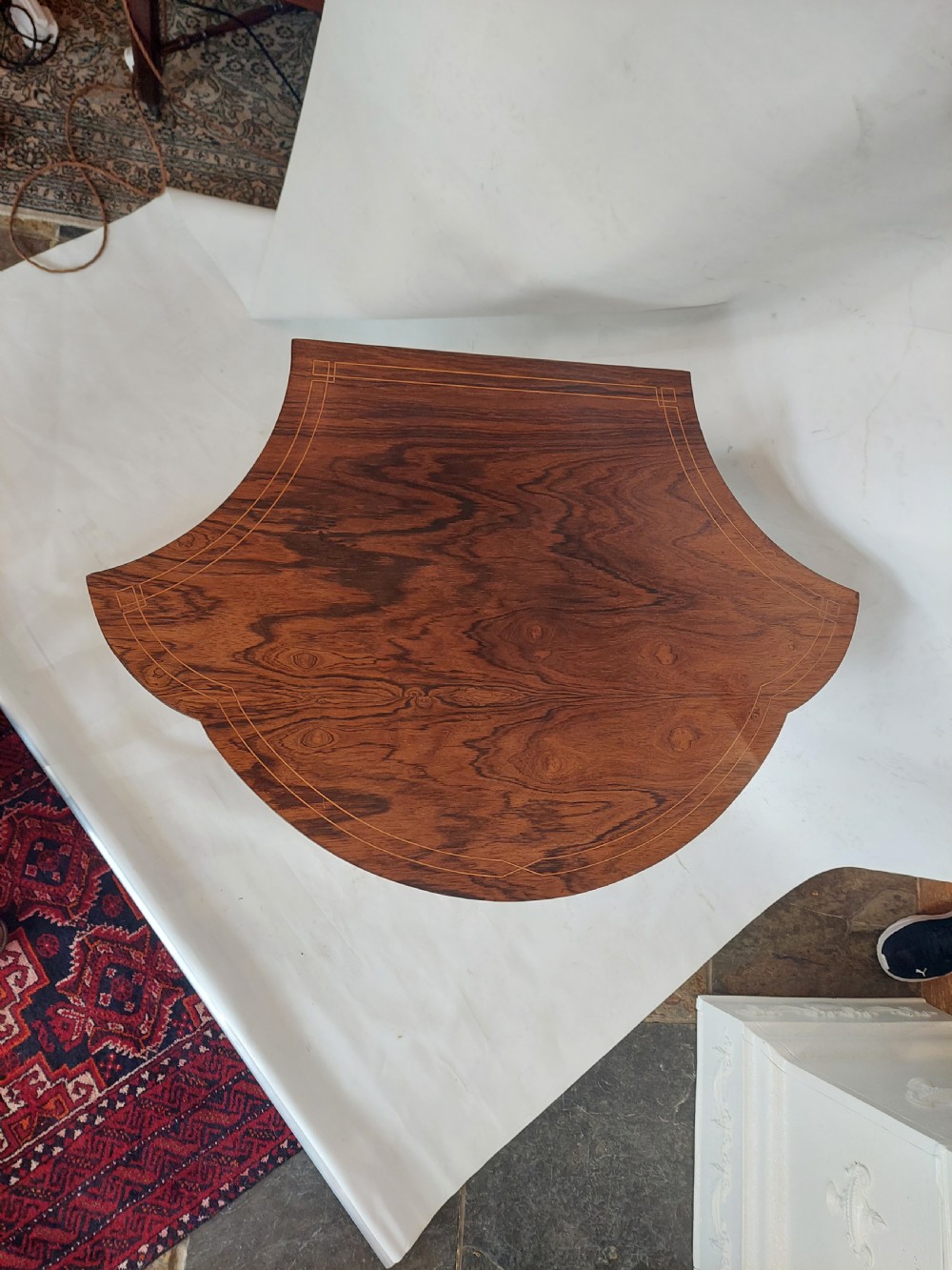 An Edwardian inlaid rosewood side table featuring a shaped top, fine line stringing, turned legs, and a curved X-form stretcher. View II