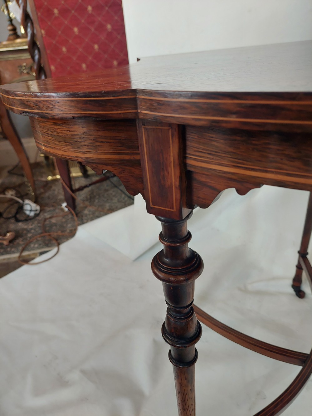 An Edwardian inlaid rosewood side table featuring a shaped top, fine line stringing, turned legs, and a curved X-form stretcher. View III