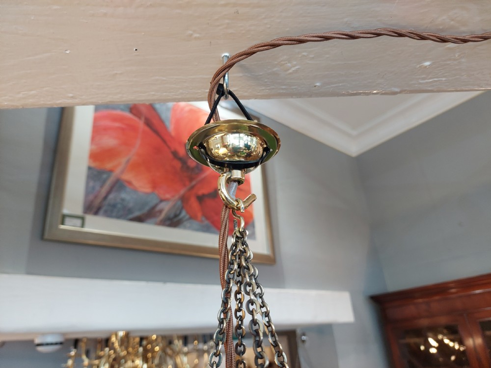 An Arts and Crafts style brass pendant lantern featuring tapered sides, suspension chains, and leaded stained glass panels decorated with stylized botanical motifs. View VII
