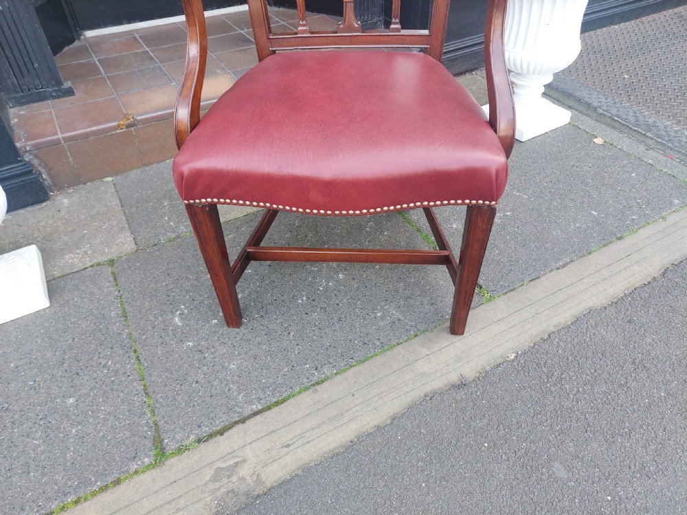 A George III mahogany carver chair featuring vertical fluted back slats, curved armrests, and a red leather seat secured with brass studding. View VIII