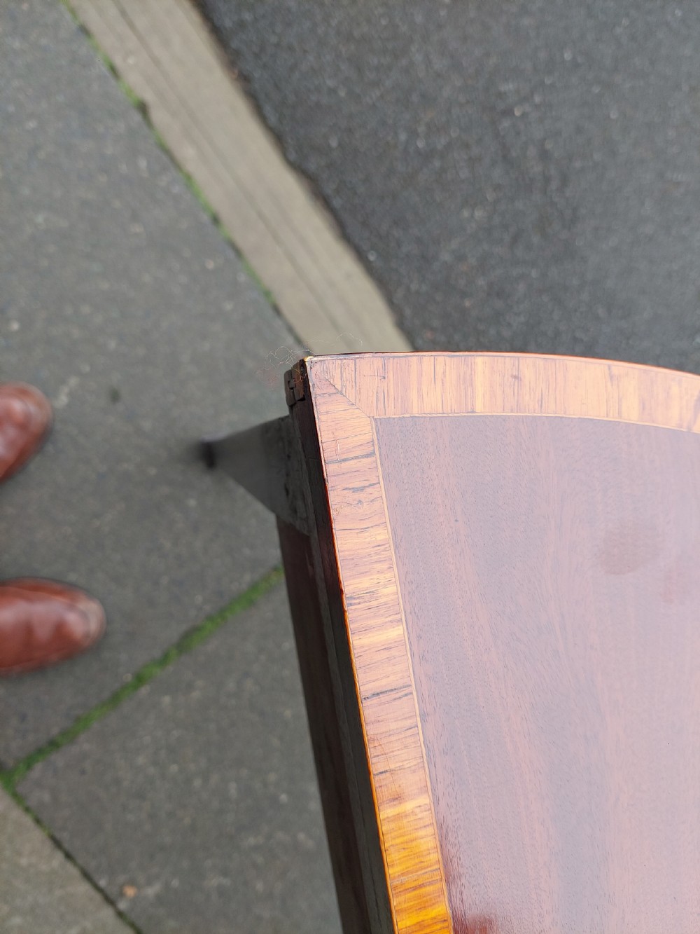 A George III mahogany demi-lune tea table featuring a fold-over top with crossbanded inlay and square tapered legs. View IV