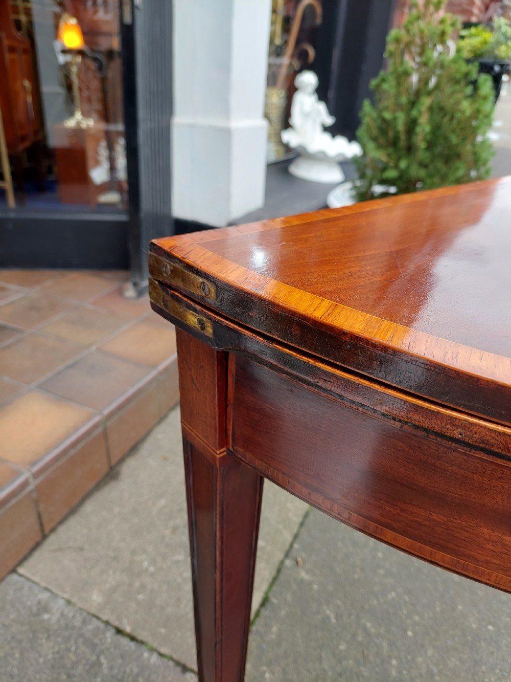 A George III mahogany demi-lune tea table featuring a fold-over top with crossbanded inlay and square tapered legs. View VIII