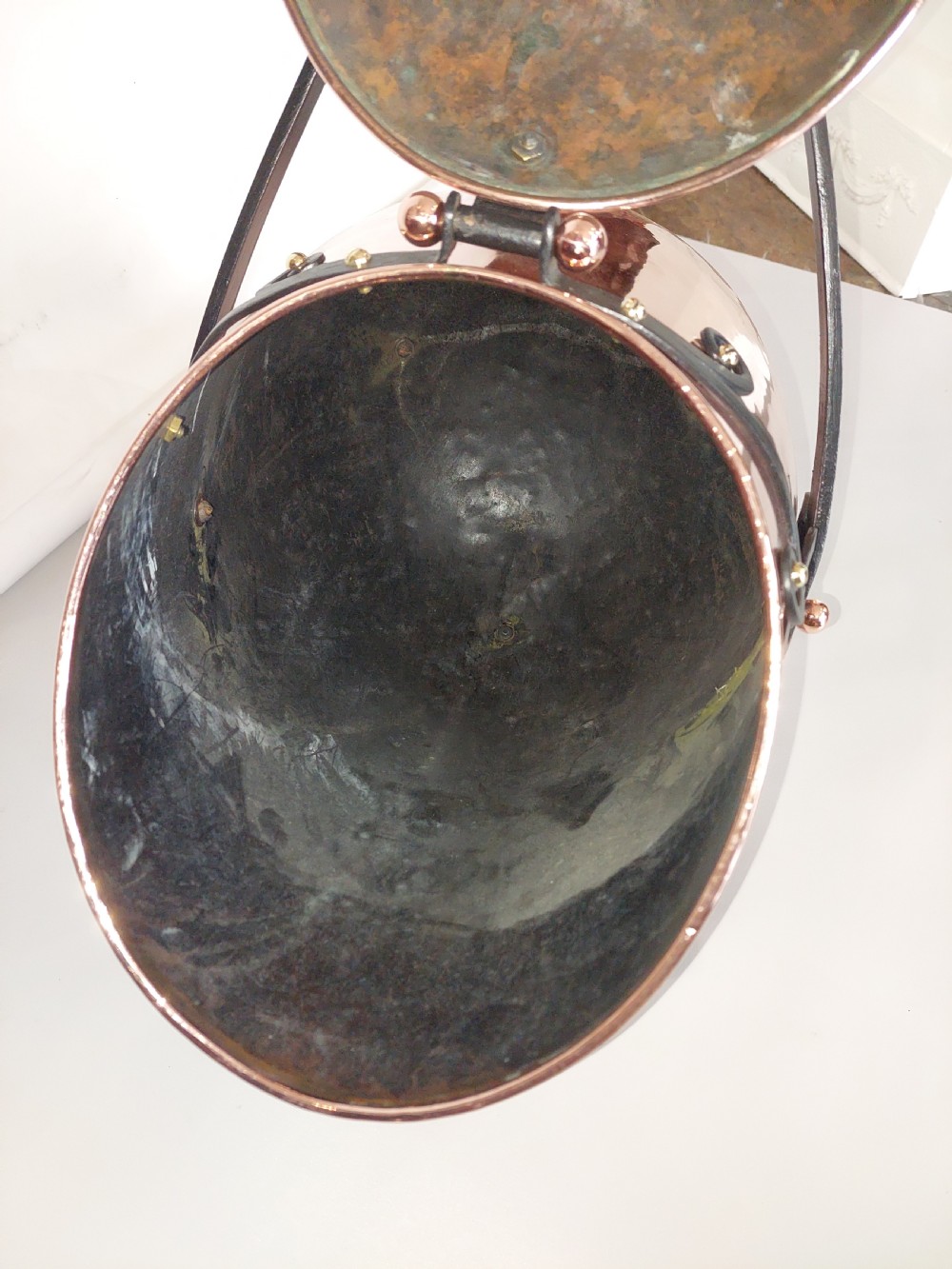 A hand-hammered copper coal receiver supported by a black wrought iron frame with scroll feet and an elevated handle. View XIV