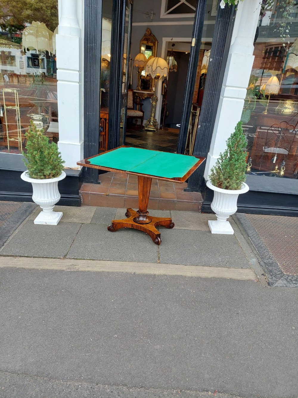 A William IV rosewood card table featuring a rectangular swivel top resting on a tapered column pedestal and a concave quadform plinth base with scroll feet. View VIII
