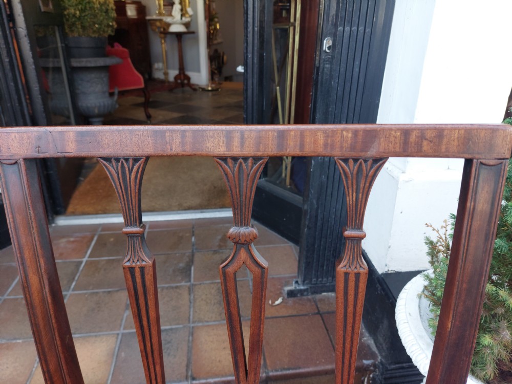 A set of four George III mahogany dining chairs featuring vertical carved back splats and blue fabric upholstered seats. View III