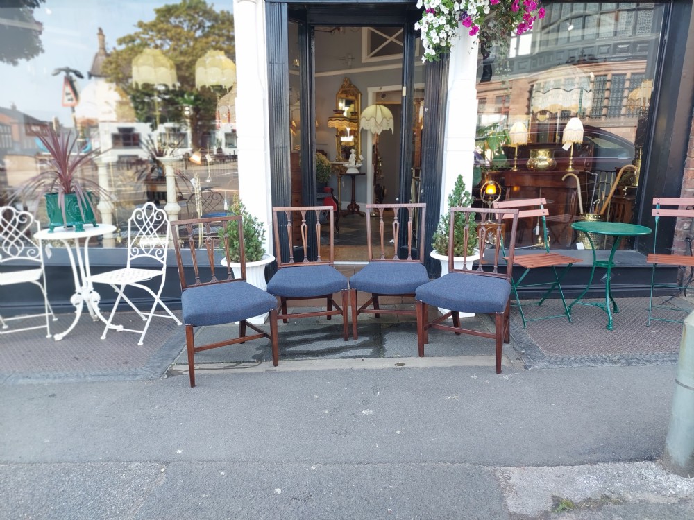 A set of four George III mahogany dining chairs featuring vertical carved back splats and blue fabric upholstered seats. View IV
