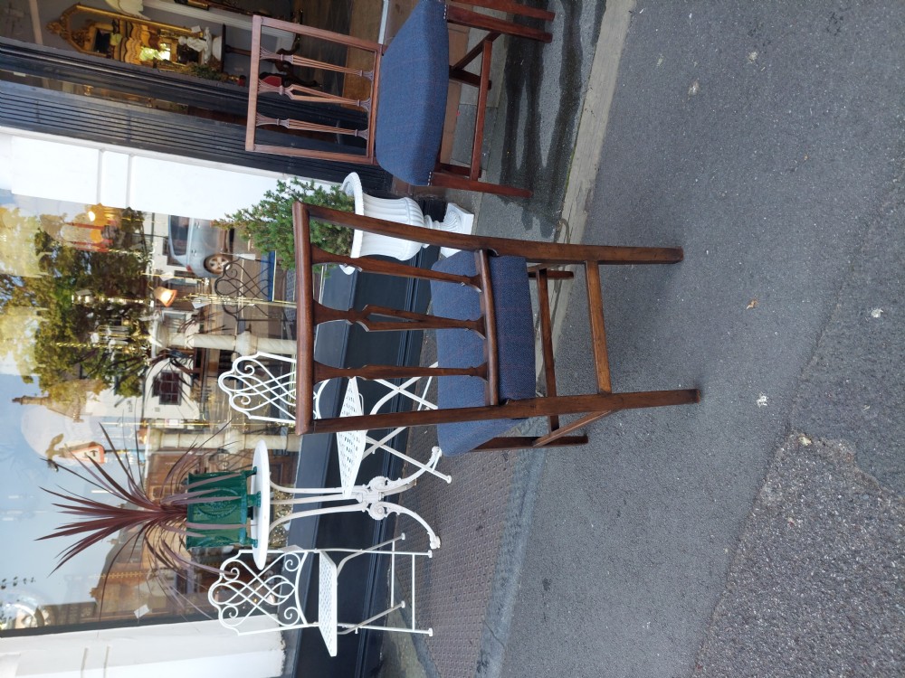 A set of four George III mahogany dining chairs featuring vertical carved back splats and blue fabric upholstered seats. View VI