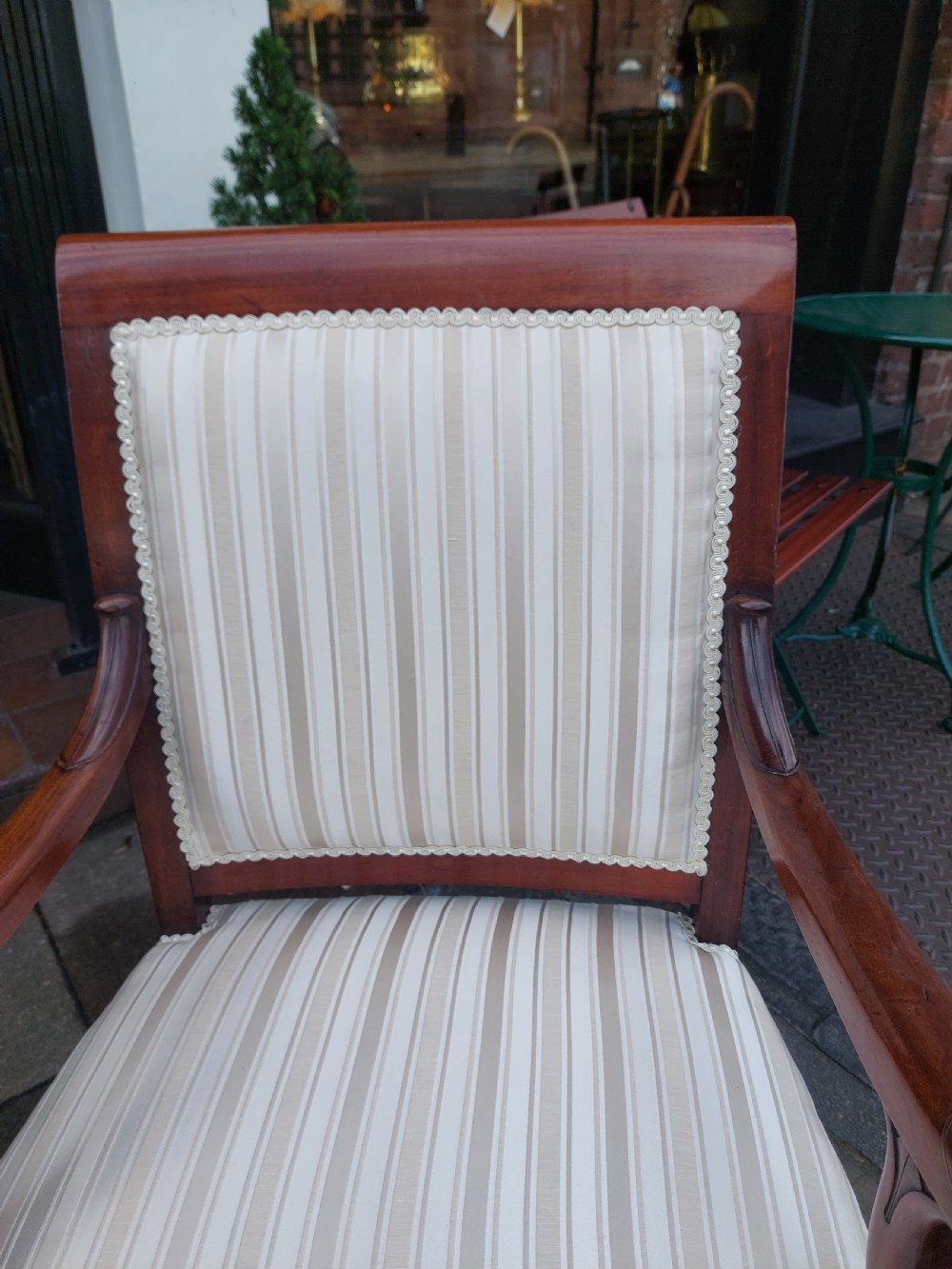 A pair of late 19th-century carved mahogany open armchairs upholstered in cream striped fabric with gimp braid trim. View III