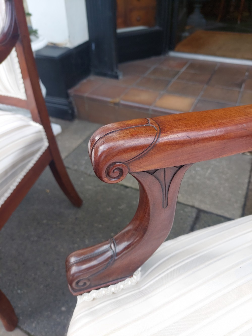 A pair of late 19th-century carved mahogany open armchairs upholstered in cream striped fabric with gimp braid trim. View IV