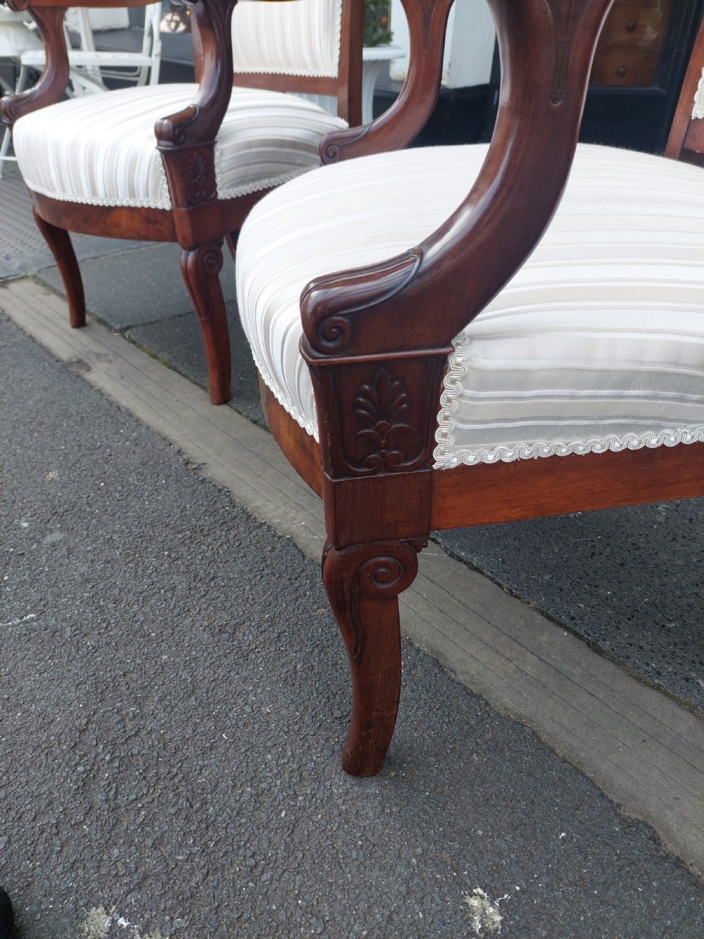 A pair of late 19th-century carved mahogany open armchairs upholstered in cream striped fabric with gimp braid trim. View VI
