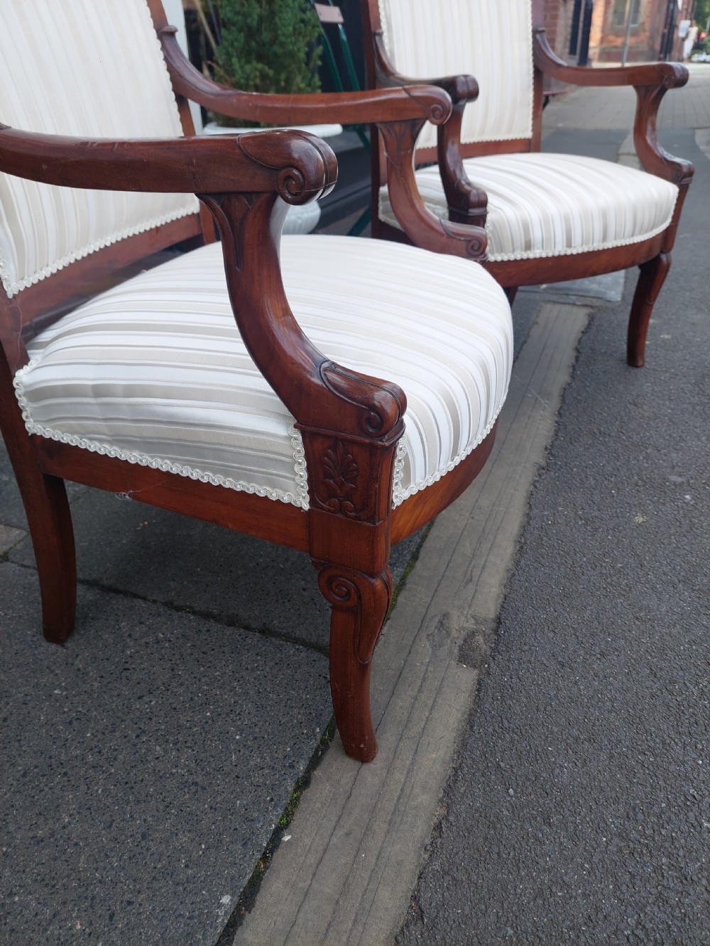 A pair of late 19th-century carved mahogany open armchairs upholstered in cream striped fabric with gimp braid trim. View VII