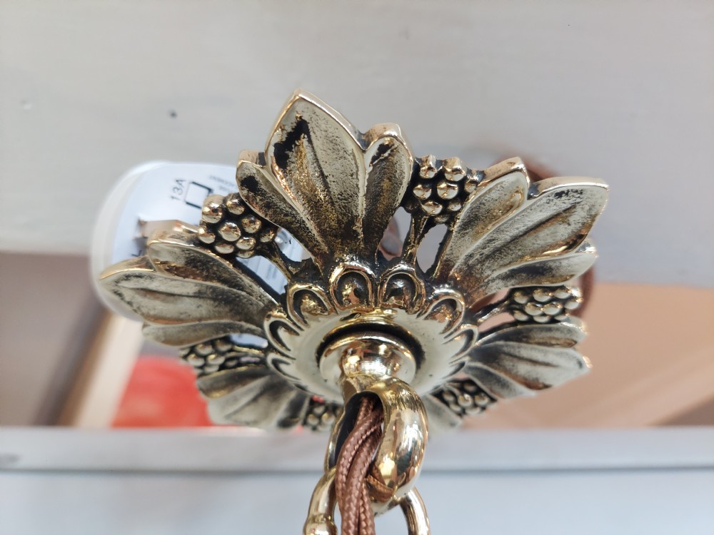 An early 20th-century brass hanging lantern featuring a cut glass shade, ornate leaf scrollwork framing, and a central suspension chain. View V