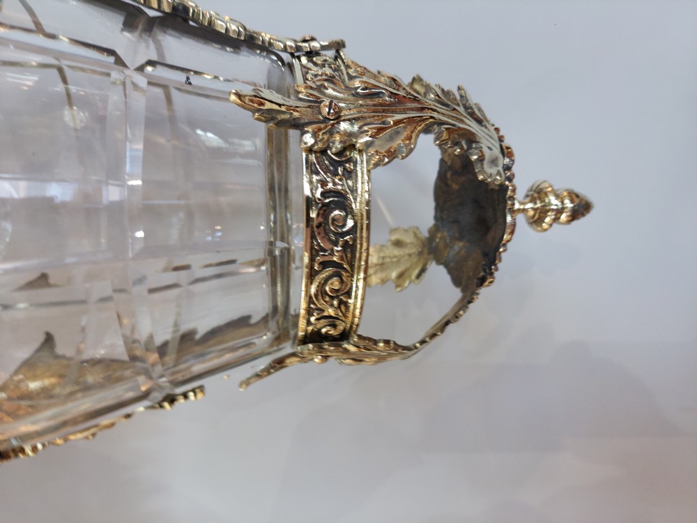 An early 20th-century brass hanging lantern featuring a cut glass shade, ornate leaf scrollwork framing, and a central suspension chain. View VIII
