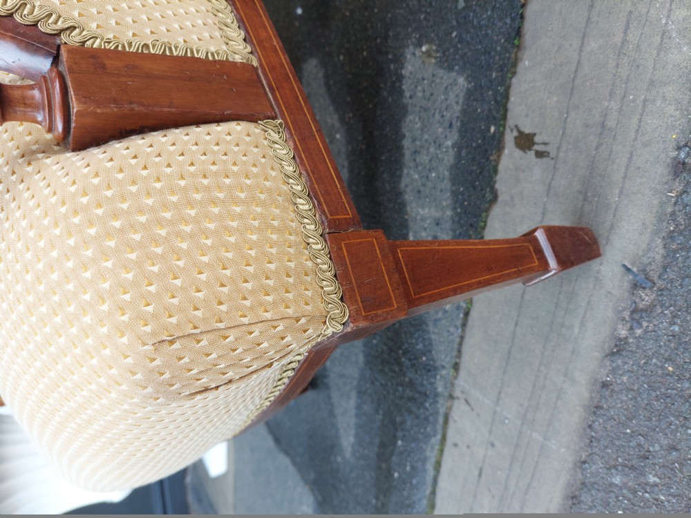 An Edwardian childs armchair with mahogany frame, marquetry patera inlay, deep-buttoned yellow pattern upholstery, and tapered square front legs. View II
