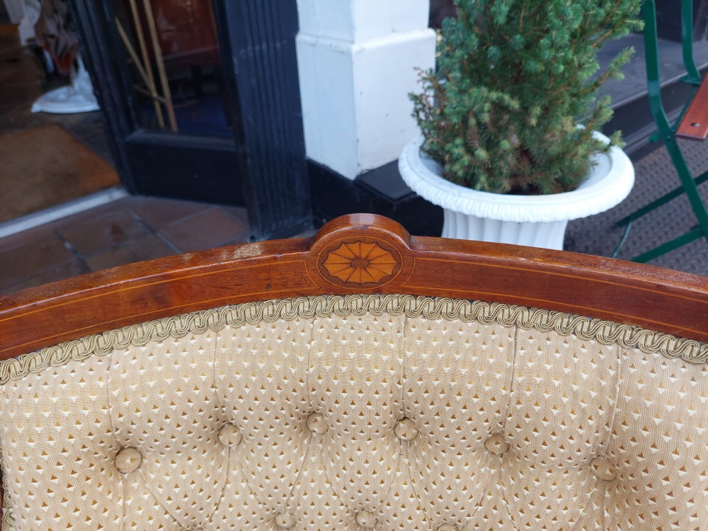 An Edwardian childs armchair with mahogany frame, marquetry patera inlay, deep-buttoned yellow pattern upholstery, and tapered square front legs. View III