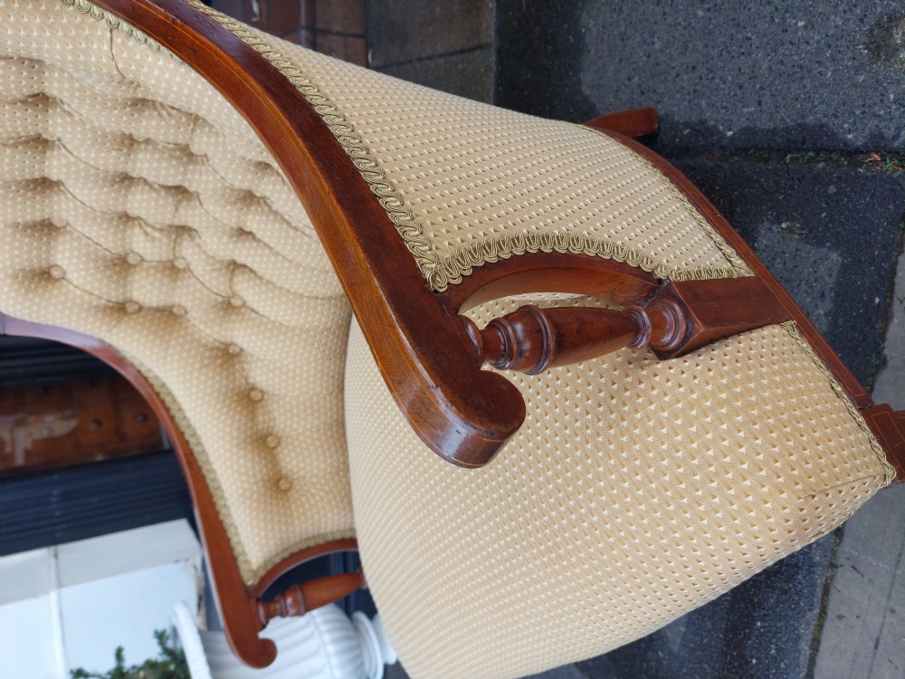 An Edwardian childs armchair with mahogany frame, marquetry patera inlay, deep-buttoned yellow pattern upholstery, and tapered square front legs. View V