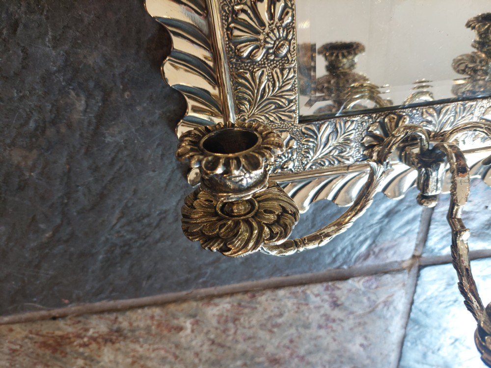 A rectangular wall mirror featuring an embossed floral metal frame with a scalloped rim and three candle branches at the base. View III