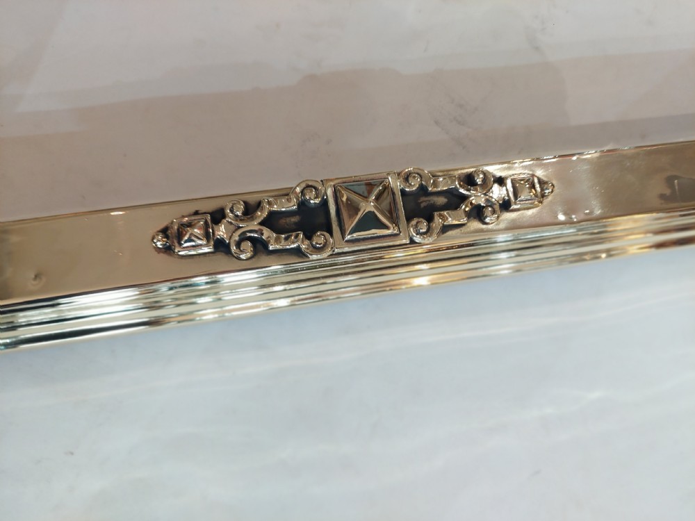 A Victorian brass and copper club fender featuring two padded brown leather corner seats raised on turned brass supports with decorative metal frieze detail. View VI