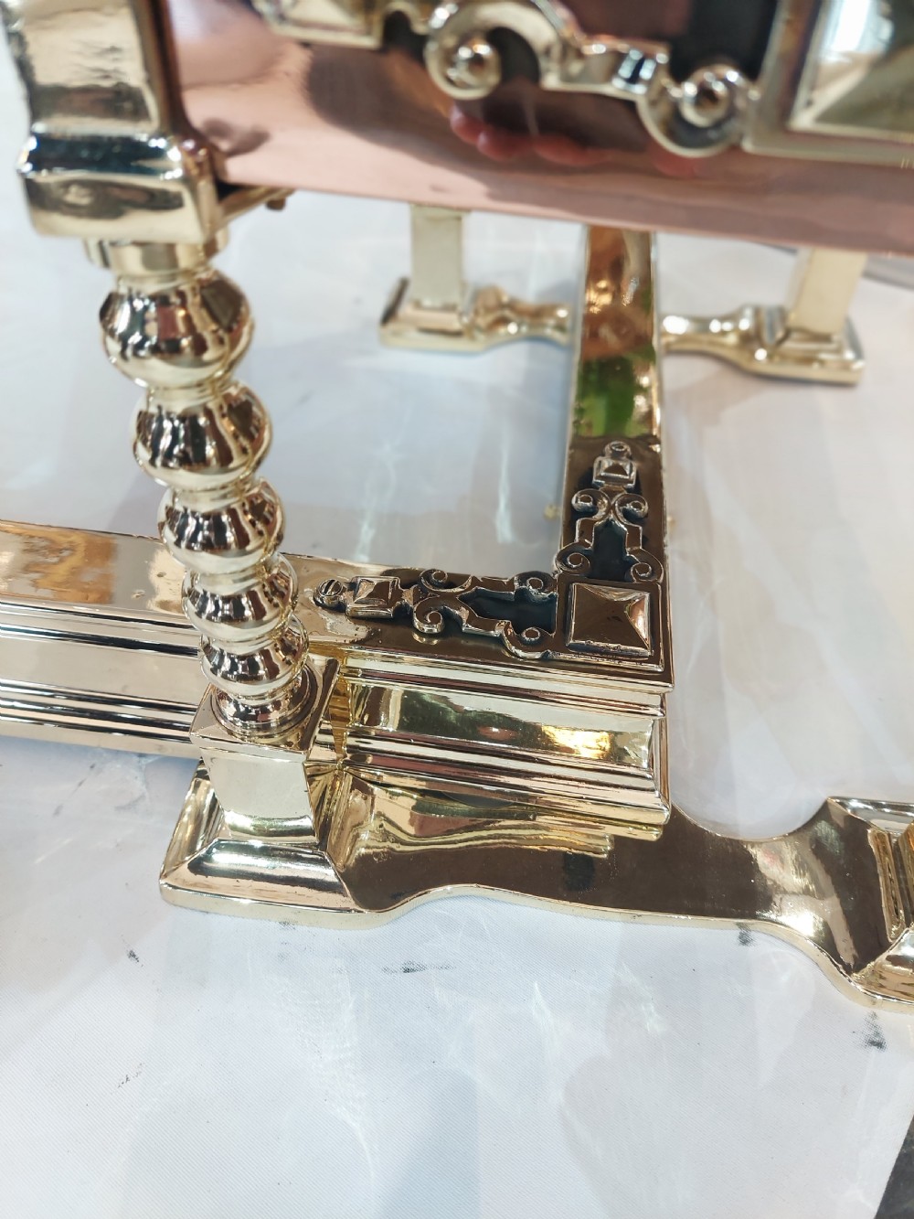 A Victorian brass and copper club fender featuring two padded brown leather corner seats raised on turned brass supports with decorative metal frieze detail. View VII