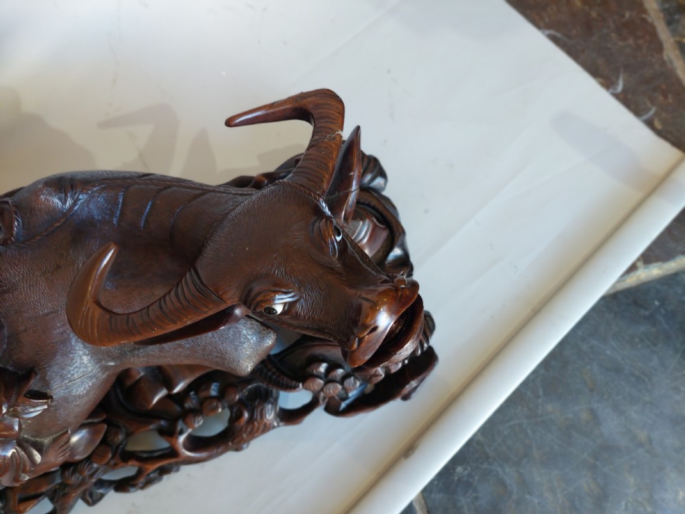 A 19th-century Chinese carved root wood sculpture depicting two boys riding a reclining water buffalo set upon a carved pierced base. View II