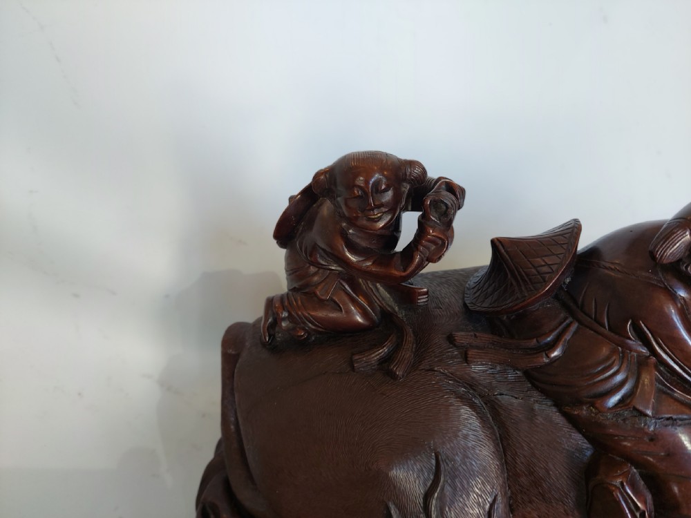 A 19th-century Chinese carved root wood sculpture depicting two boys riding a reclining water buffalo set upon a carved pierced base. View V