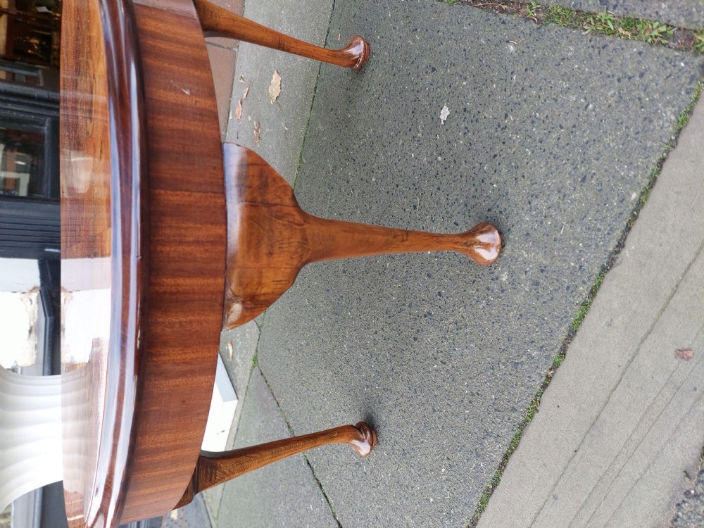A circular 1920s burr walnut coffee table featuring cabriole legs with pad feet and a figure-grained veneer top. View II