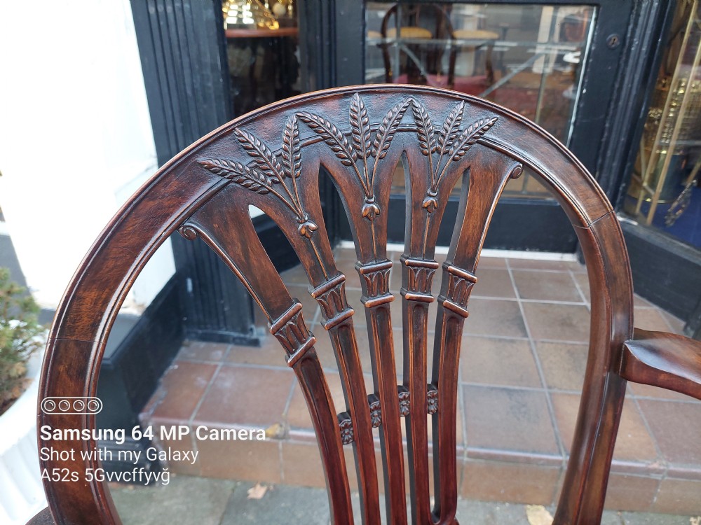 A late 19th-century Hepplewhite style mahogany armchair featuring a carved wheat sheaf oval backrest, curved arms, and a red velvet upholstered seat. View II