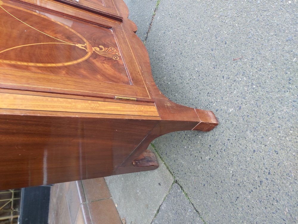 An Edwardian mahogany waterfall bookcase featuring two open graduated shelves above a two-door cabinet with oval satinwood marquetry inlay. View III