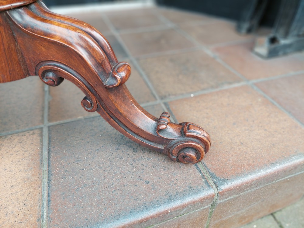 A Victorian dark walnut rise and fall piano stool with a circular cream upholstered seat and three carved cabriole legs with scroll feet. View II