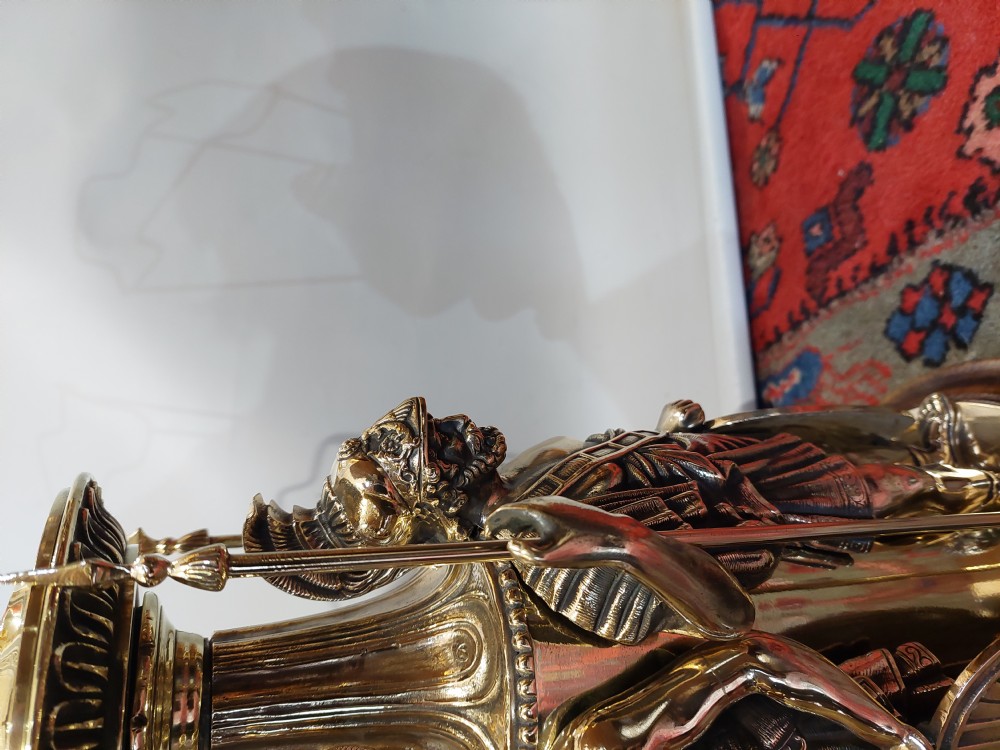 A late nineteenth-century brass table lamp featuring a sculptural base with classical soldier figures and a patterned hexagonal shade with long fringe. View V