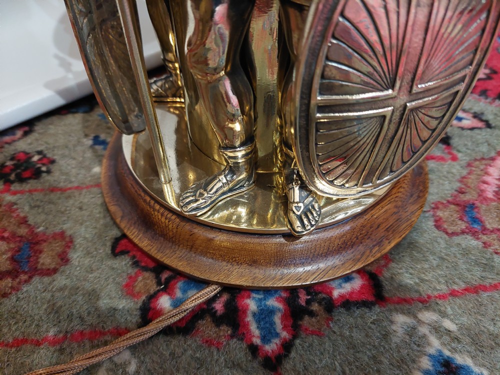 A late nineteenth-century brass table lamp featuring a sculptural base with classical soldier figures and a patterned hexagonal shade with long fringe. View VI