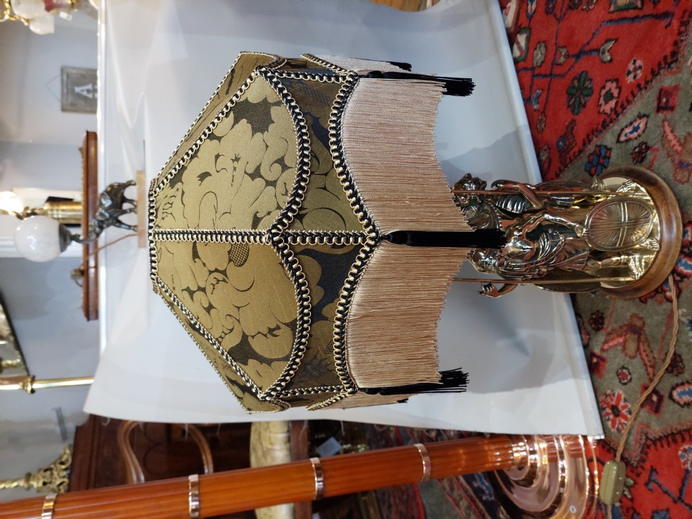 A late nineteenth-century brass table lamp featuring a sculptural base with classical soldier figures and a patterned hexagonal shade with long fringe. View VII
