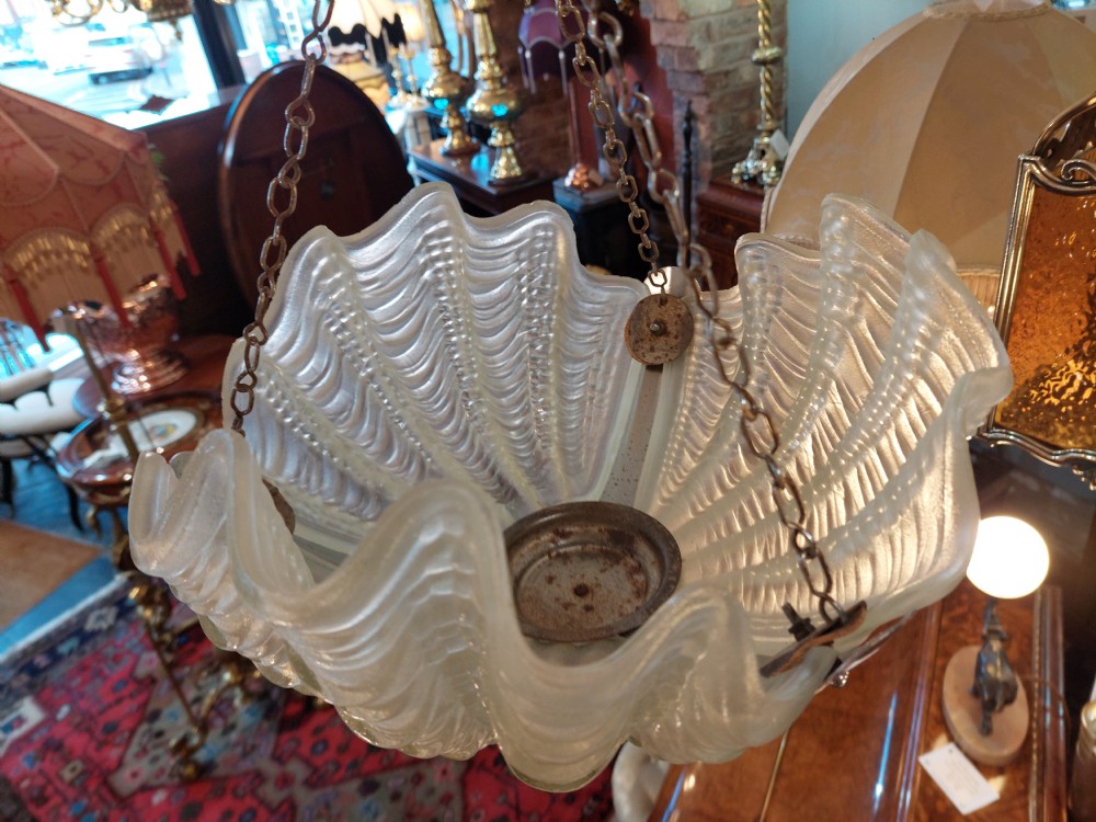 An Art Deco ceiling light fixture featuring three cream frosted glass clam shell shades held together by chrome brackets and suspended by three metal chains. View VIII