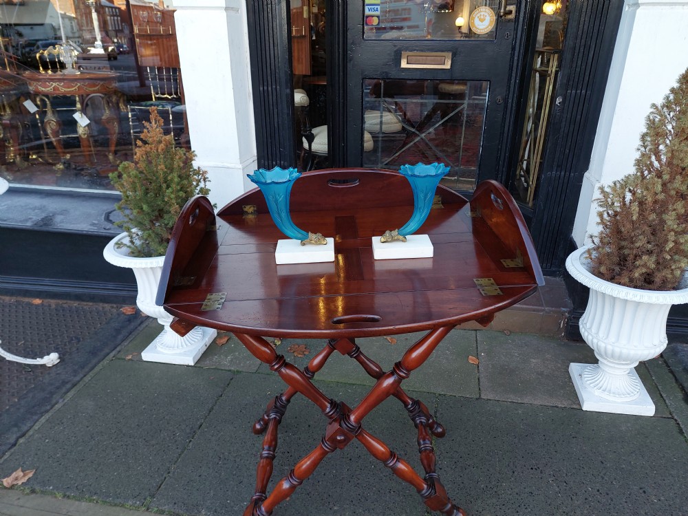An early 19th-century Cuban mahogany oval butlers tray with hinged folding sides, brass fittings, and a turned X-frame stand. View III