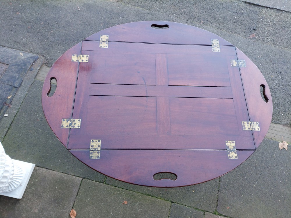 An early 19th-century Cuban mahogany oval butlers tray with hinged folding sides, brass fittings, and a turned X-frame stand. View IV