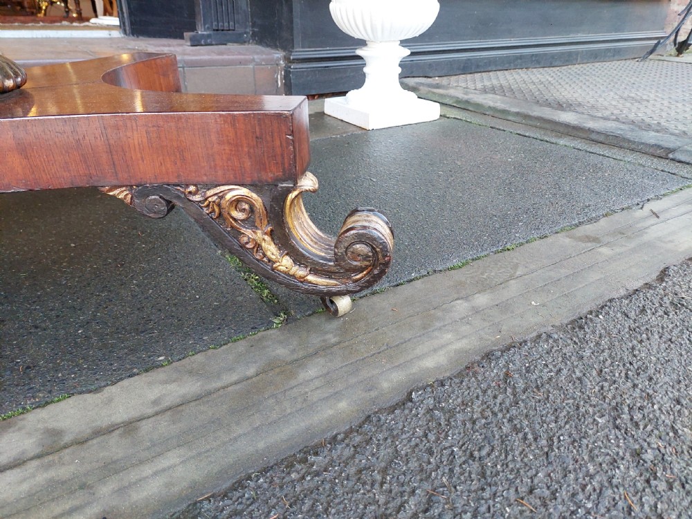 A Regency rosewood drop-leaf sofa table with twin inlaid drawers, a carved parcel gilt pedestal column, and a quadruped base ending in scroll feet. View VII
