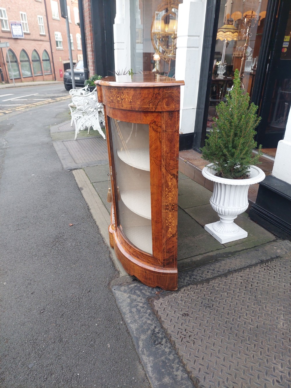 A Victorian burr walnut bow-fronted credenza featuring central inlaid wooden doors flanked by curved glazed display sections with ormolu mounts. View IX