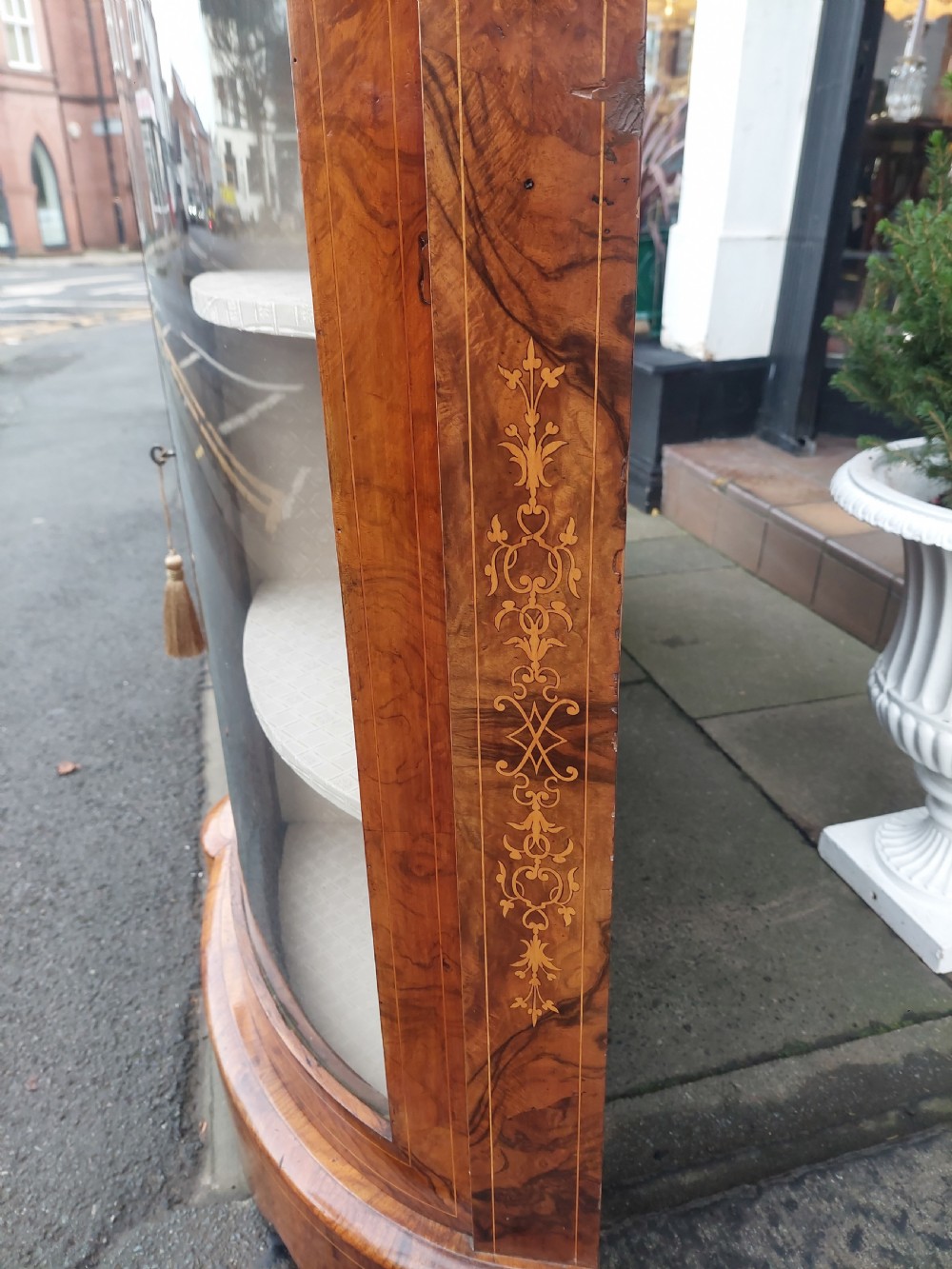 A Victorian burr walnut bow-fronted credenza featuring central inlaid wooden doors flanked by curved glazed display sections with ormolu mounts. View X